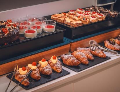 Breakfast buffet at Hotel Villa Alberta with a variety of croissants, pastries and small desserts.
