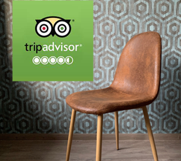 Logo verde di Tripadvisor davanti a una parete decorata con motivi geometrici, una sedia marrone e pavimento in legno.