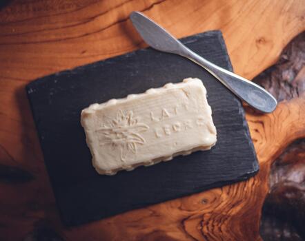 Nahaufnahme von Butter auf einer schwarzen Servierplatte mit Buttermesser am Frühstücksbuffet im Hotel Villa Alberta.
