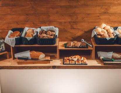 Breakfast buffet at Hotel Villa Alberta with various types of bread, a toaster and savoury pastries.